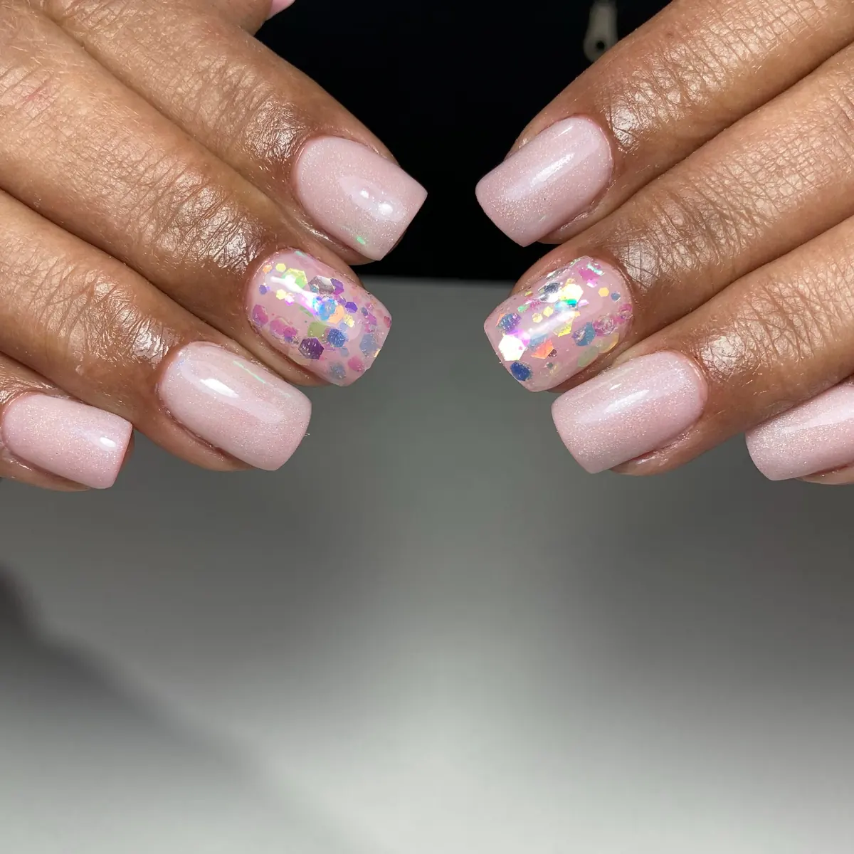 Uñas cortas rosa con glitter holográfico